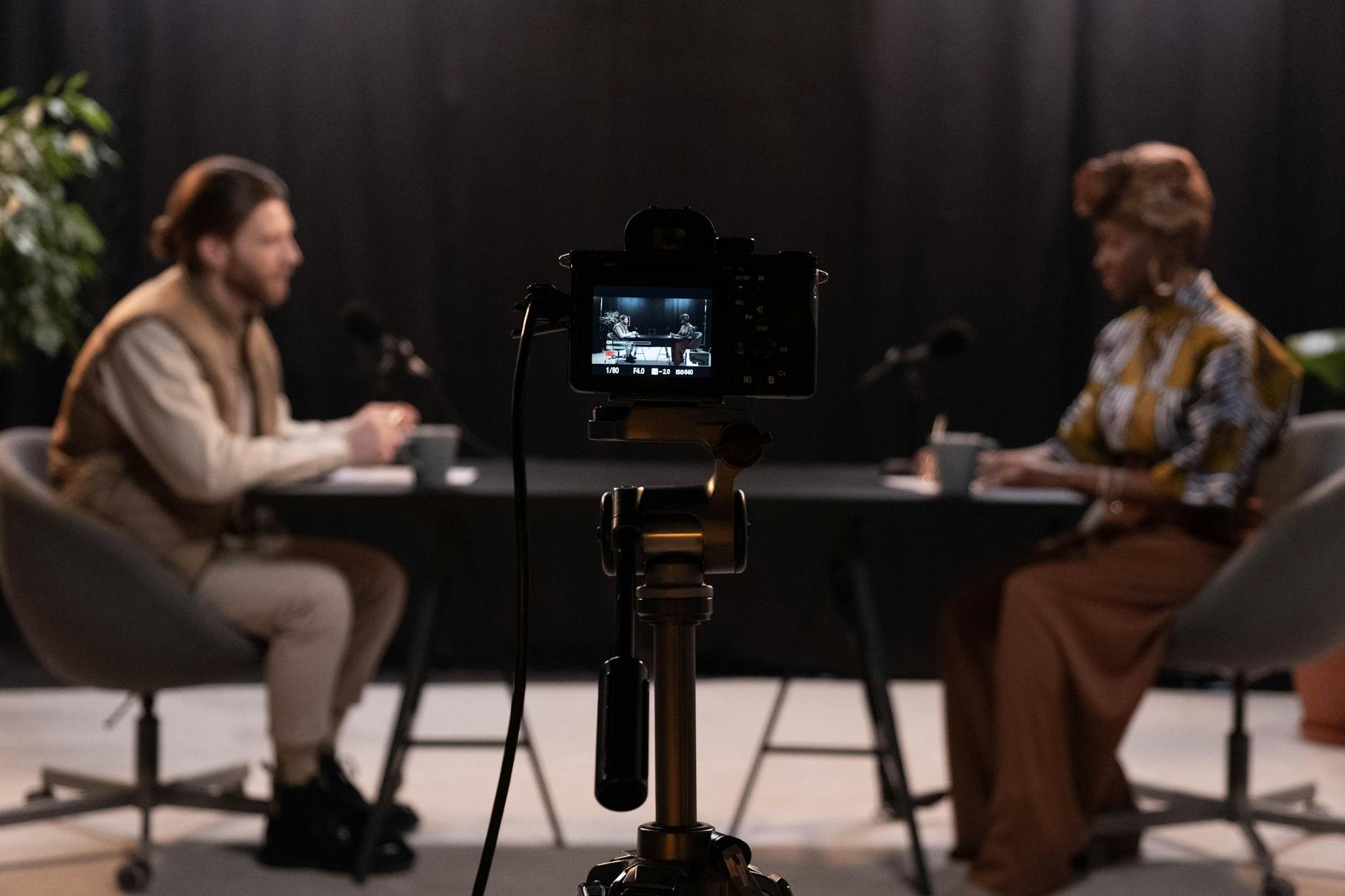KB Marketing - Two hosts recording a podcast in a studio setting with professional equipment.