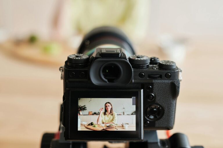KB Marketing - Caucasian woman vlogging at home with camera in a kitchen setting, captured indoors.